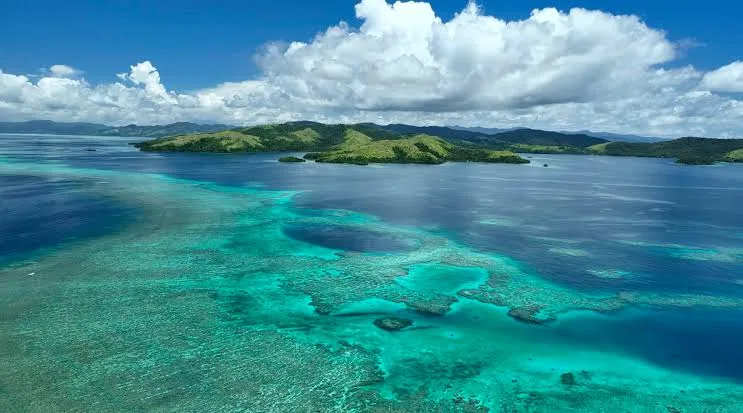 Aerial view of turquoise reef channels and green islands around Taveuni
