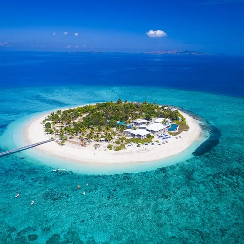 Aerial view of a small island resort surrounded by turquoise water in the Mamanucas