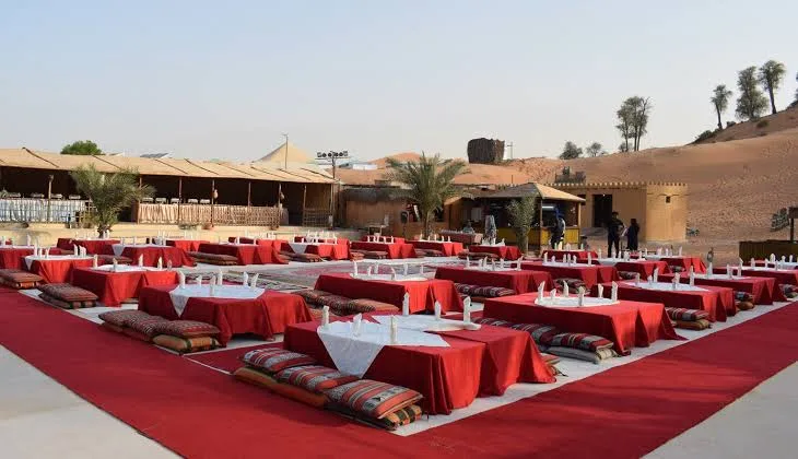 Low tables and cushions laid out at a Bedouin-style desert camp