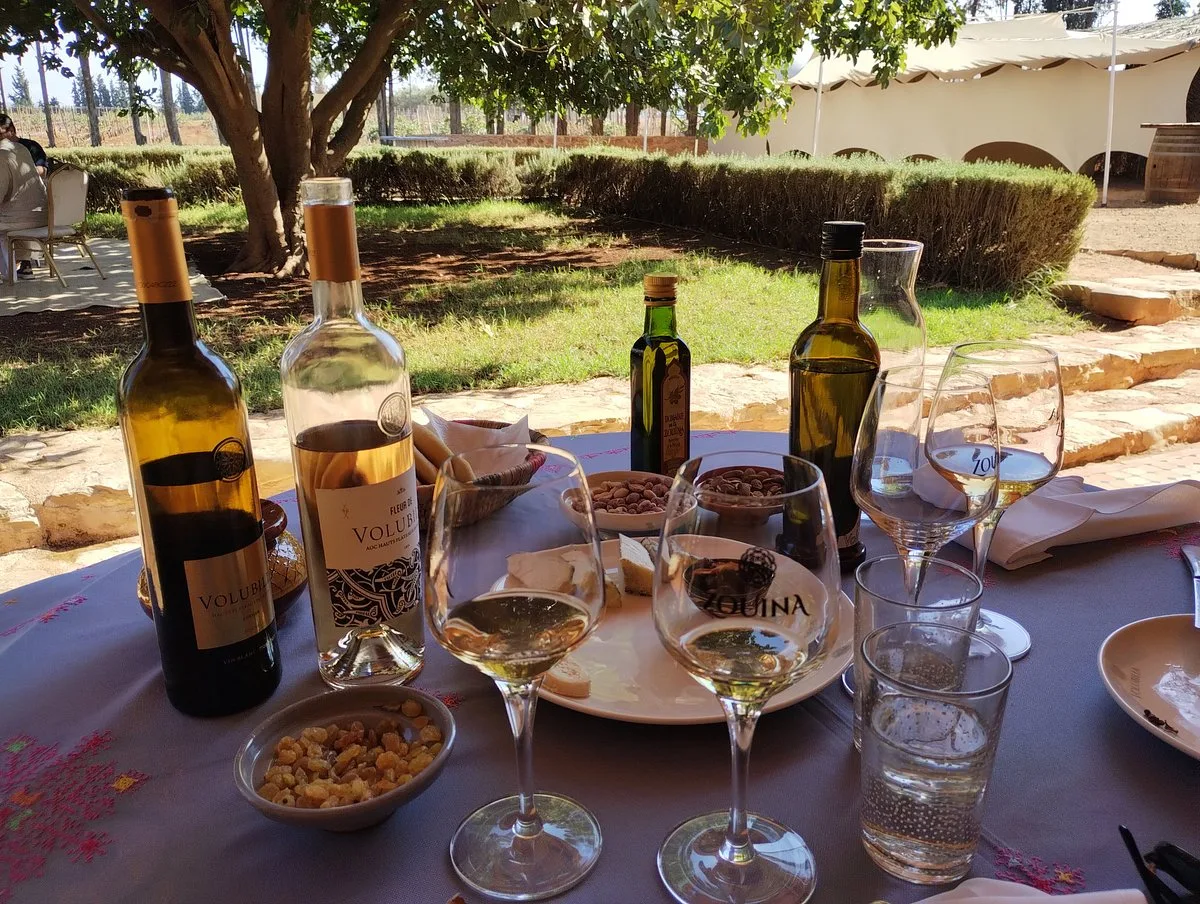 Wine bottles and tasting glasses on an outdoor table at Domaine de la Zouina