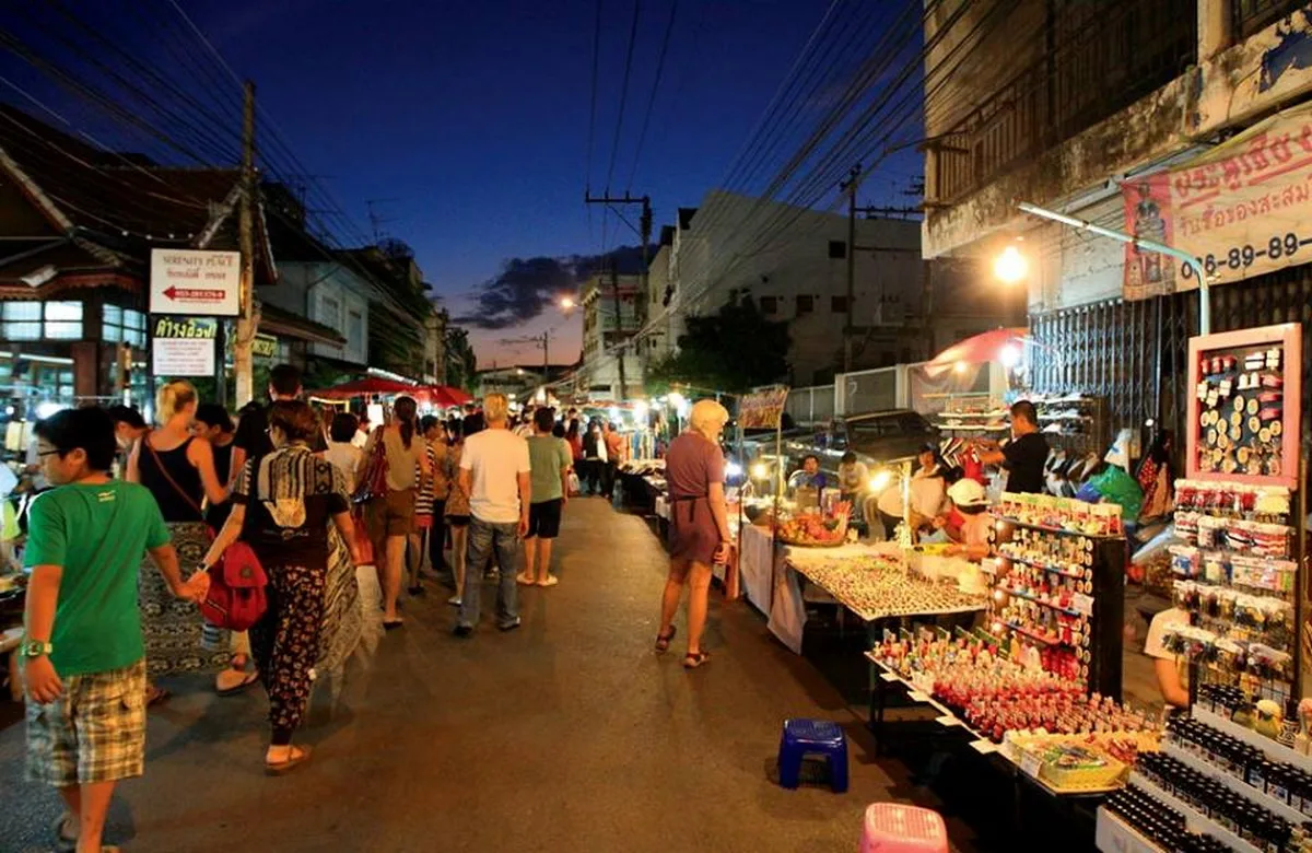 Shoppers browsing stalls as dusk falls over Saturday Walking Street in Chiang Rai