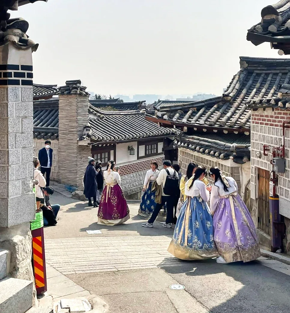 Visitors in colourful hanbok walking the tiled lanes of Bukchon Hanok Village