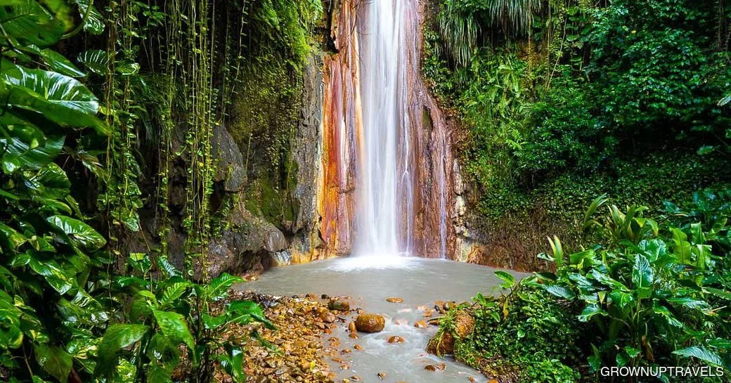 Mineral-streaked Diamond Falls cascading into a rainforest pool