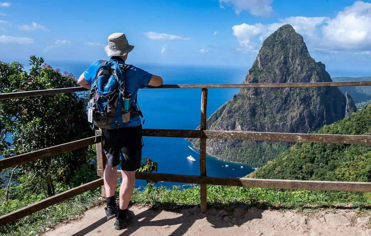 A hiker at a viewpoint on the Tet Paul Nature Trail overlooking the Pitons